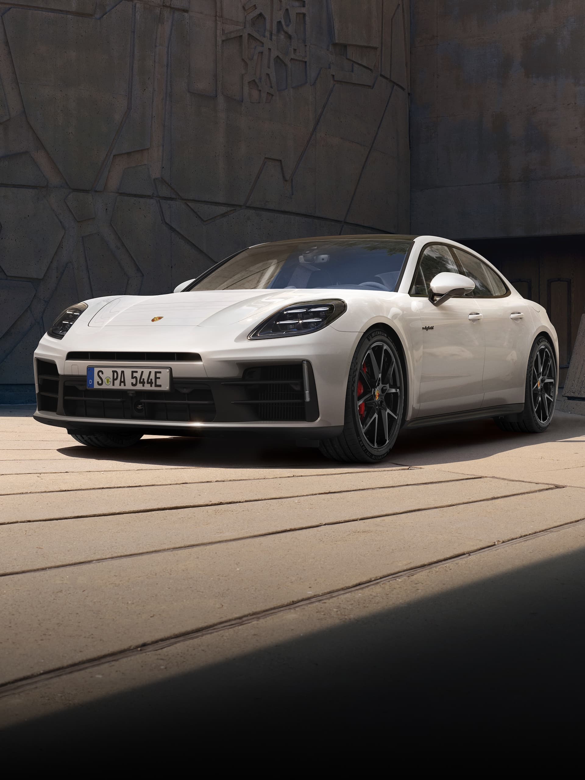 Ein Porsche Panamera parkte vor einem modernen Gebäude.